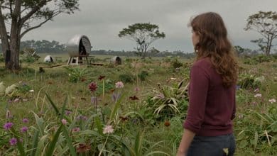 Lana e sua companheira Mui atravessam uma paisagem alienígena pintada à mão, com vegetação exuberante e máquinas misteriosas ao longe.